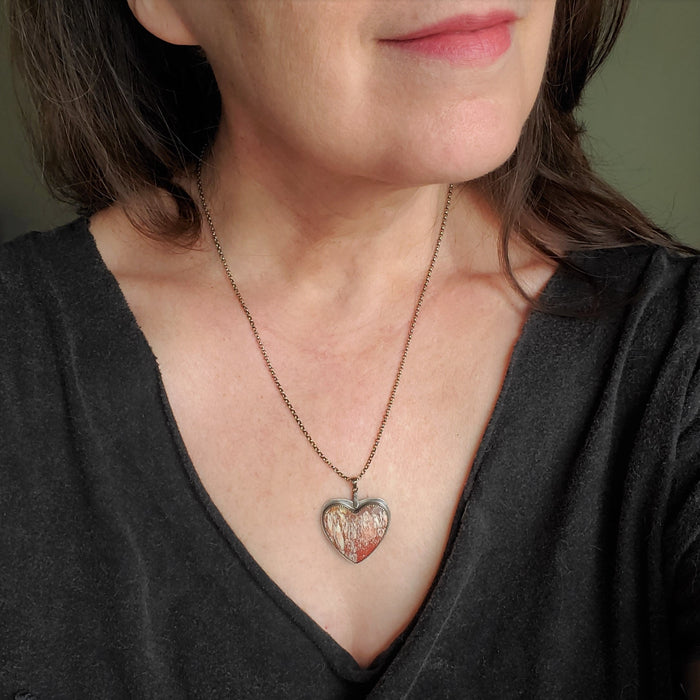 Alunite heart gemstone pendant on model